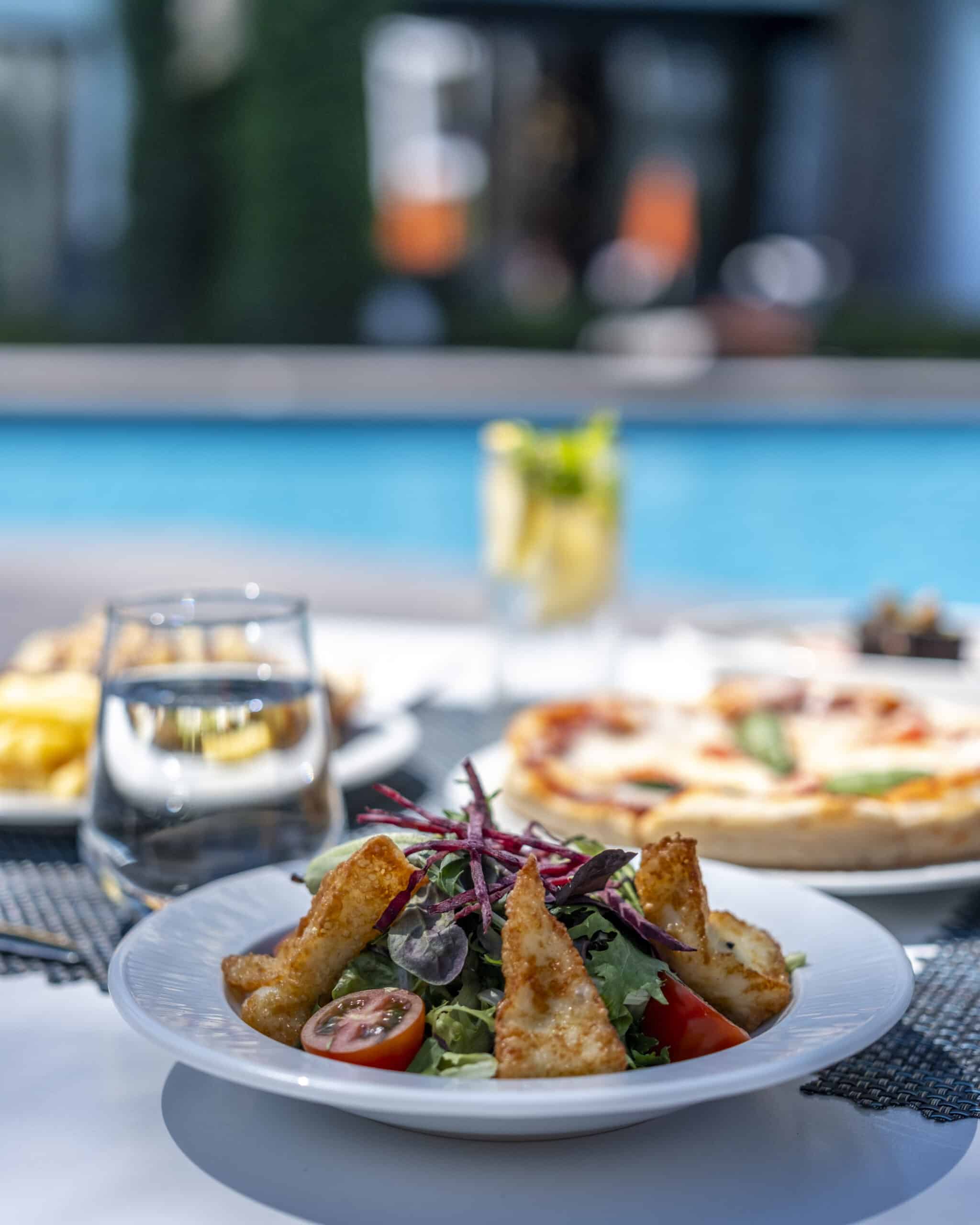 Salata, pizza ve içecekler.