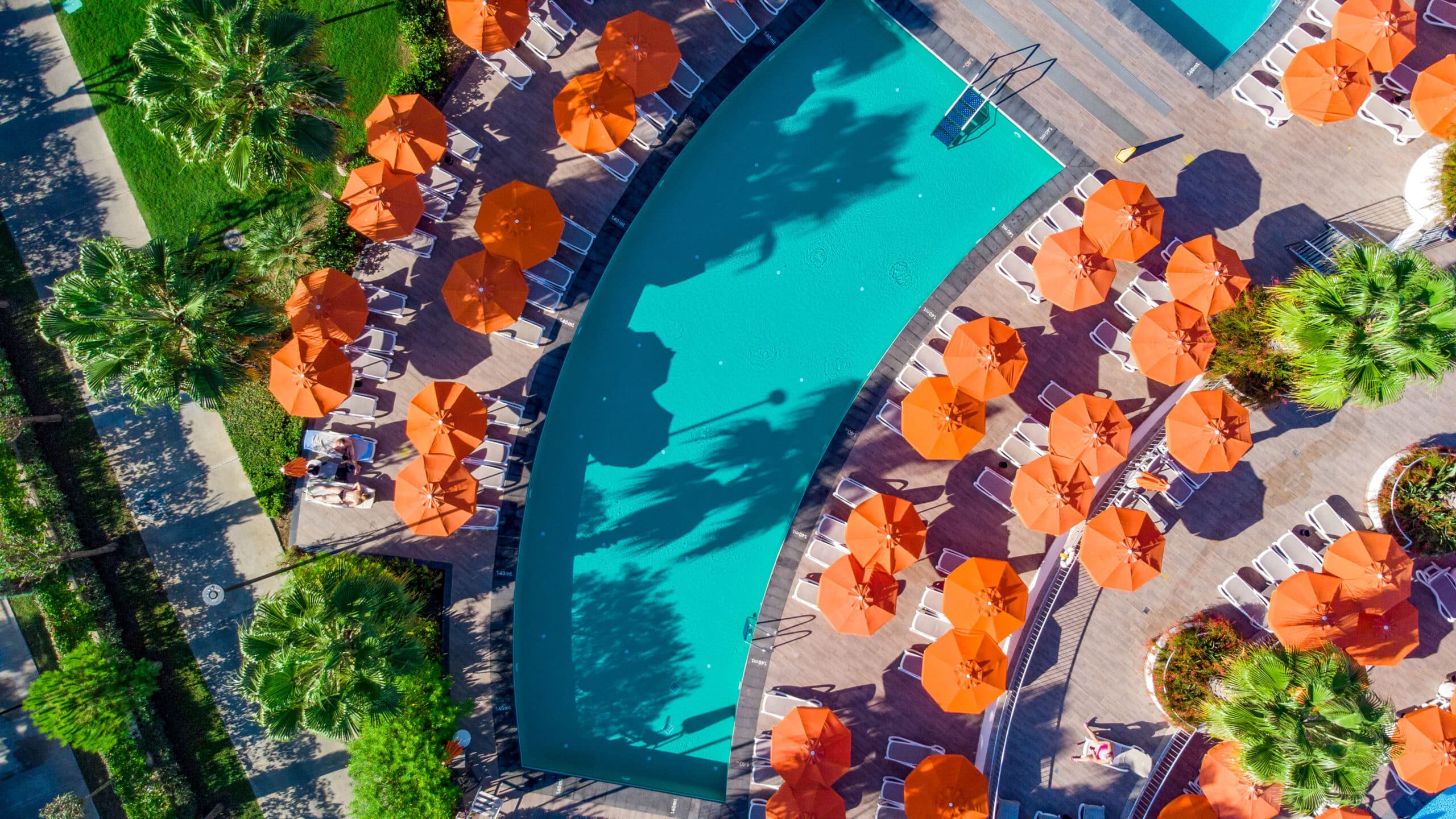 Turkuaz havuz, turuncu şemsiyeler.